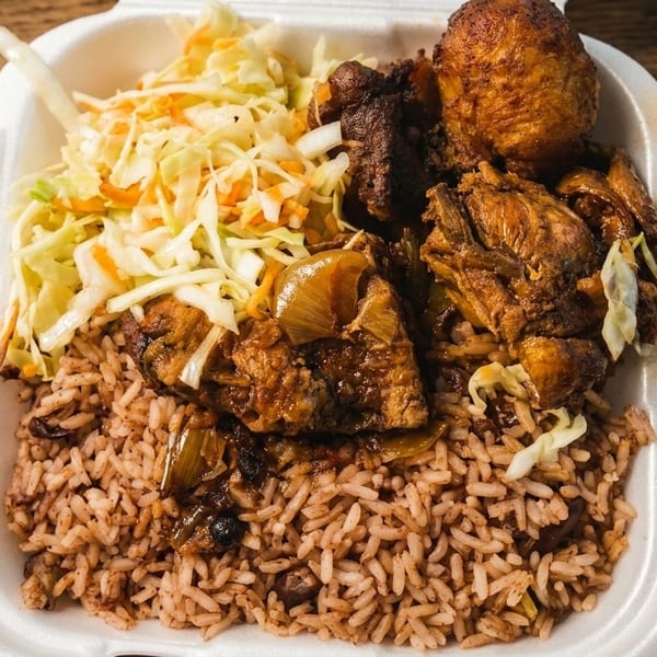 A takeout container filled with brown rice, stewed chicken, and coleslaw on a wooden table.